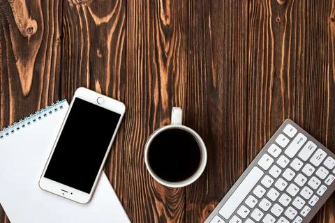 Top view office wooden desk with a cup of coffee and smartphone - Copyspace Stock Photos