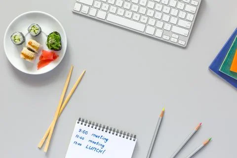 Top View Office Work Place on grey Desk Sushi Schedule Stock Photos
