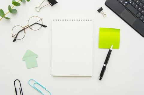 Top view of office workplace with blank spiral notepad, glasses, supplies and Stock Photos