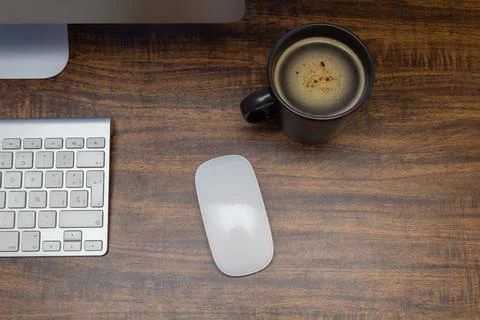 Top view of office workspace with computer monitor, keyboard, mouse and cup o Stock Photos
