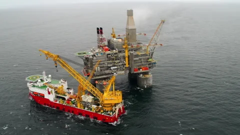 Top view of an offshore oil platform with a support vessel next to it. Stock Footage 247650801