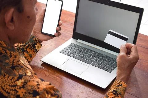 Top view Old man doing financial transaction with the white blank credit card, Foto stock