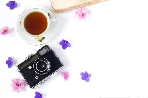 Top view of old retro camera and old book on white background with pink flowe Stock Photos