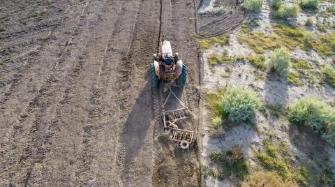 Top view of old tractor plowing. Aerial photo. Stock Photos