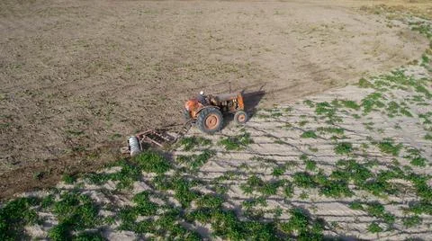 Top view of old tractor plowing. Aerial photo. Stock Photos