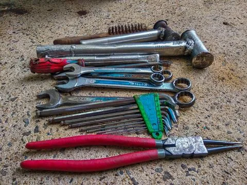 Top view of old workshop tools, welded hammers, and wrenches on concrete floor Stock Photos