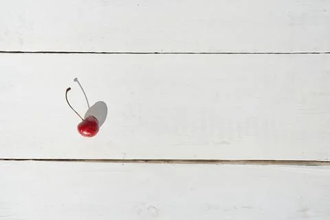 Top view of one cherry berry with a natural shade. Cherry on a white wooden Fotos de archivo