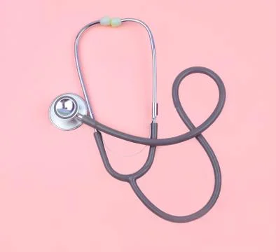 Top view of one single normal stethoscope isolated on top of a pink color pap Stock Photos