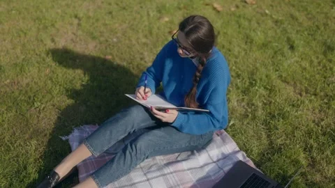 Top view of one woman thinking and writing in notebook in cinematic lifestyle. Stock Footage 332759939