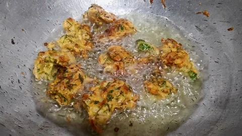 A top view of onion pakora or crispy fritters being deep fried in hot oil o.. Stock Footage 314031219