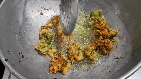 A top view of onion pakora or crispy fritters being deep fried in hot oil o.. Stock Footage 314031686