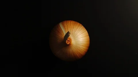 TOP VIEW: Onion rotates on a black surface - Stop motion Vídeo Stock 100258207