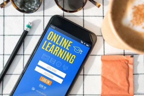 Top view online learning log in  feature on mobile screen with coffee cup,sun Foto stock
