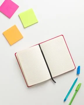Top view of an open blank red notebook in the center, colored reminders in hi Stock Photos