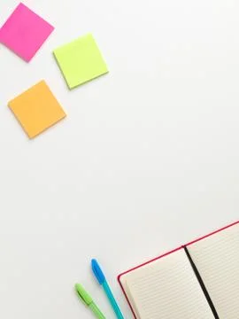 Top view of an open blank red notebook in the bottom corner with a green pen  写真素材