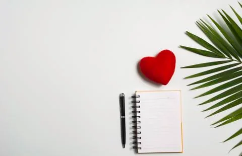 Top view of open book with red heart. Book open with pen on white background. Foto stock
