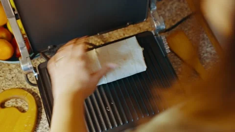 Top view of an open hot electric grill and stuffed pita bread placed on it. Stock Footage 237538637