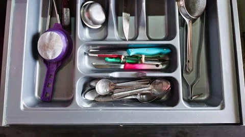 Top view of an open kitchen drawer with gray plastic cutlery organizer tray 스톡 동영상 326988552