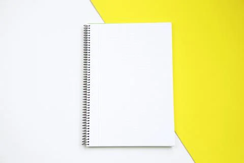 Top view of an open notebook against white and yellow background Stock Photos