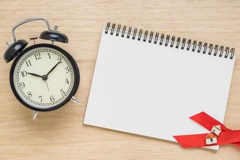 Top view of open notebook with clock on wood background Stock Photos