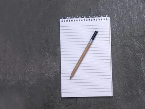 Top view of a open notebook with lined paper and pencil on a slate backgrou.. Stock Photos