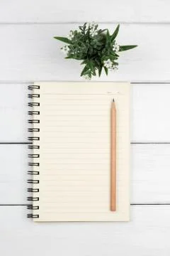 Top view of an open notebook with pencil on white wooden desk Stock Photos
