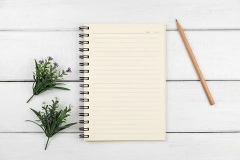 Top view of an open notebook with pencil on white wooden desk Stock Photos