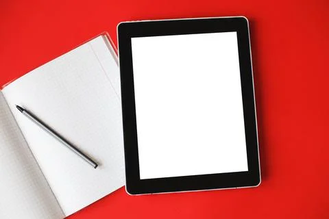 Top view open notepad and a gadget with mock up on red background. Stock Photos