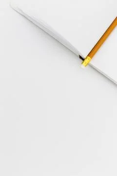Top view of an open notepad with a pencil on a white table background Stock Photos