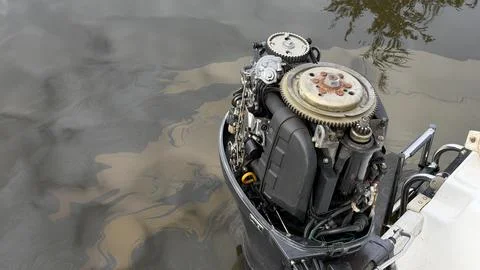 Top view of an open outboard boat motor mounted on a vessel floating on a calm Stock Photos