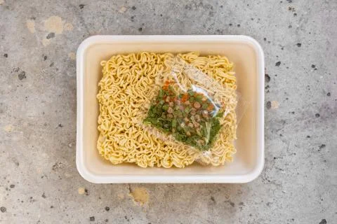 Top view open plastic box with raw instant noodles with seasoning Foto stock