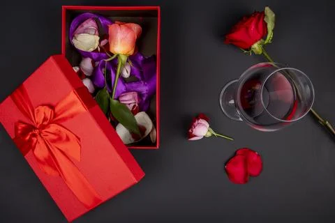Top view of an open red present box with rose flower and a glass of red win.. Stock Photos
