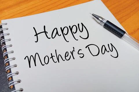 Top view of an open spiral notebook with Happy Mother's Day handwritten tex.. Stock Photos