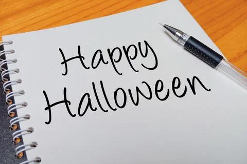 Top view of an open spiral notebook with Happy Halloween handwritten text o.. Stock Photos