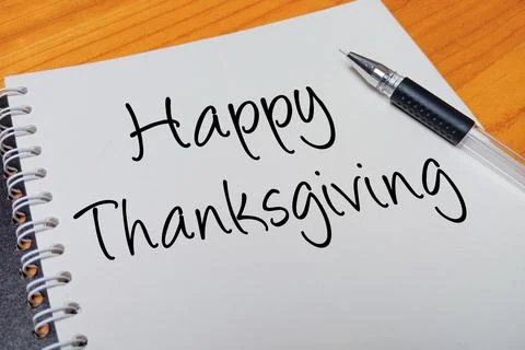 Top view of an open spiral notebook with Happy Thanksgiving handwritten tex.. Stock Photos