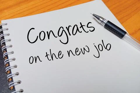 Top view of an open spiral notebook with Congrats on the new job handwritte.. Stock Photos