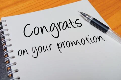 Top view of an open spiral notebook with Congrats on your promotion handwri.. Stock Photos