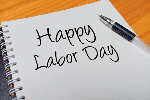 Top view of an open spiral notebook with Happy Labor Day handwritten text o.. Stock Photos