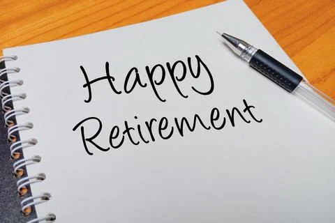 Top view of an open spiral notebook with Happy Retirement handwritten text .. Stock Photos