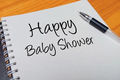 Top view of an open spiral notebook with Happy Baby Shower handwritten text.. Stock Photos