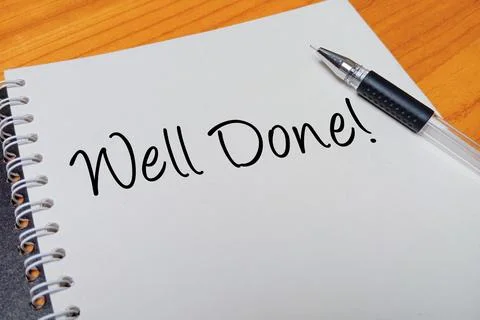 Top view of an open spiral notebook with Well Done! handwritten text overla.. Stock Photos