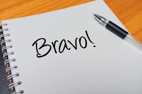 Top view of an open spiral notebook with Bravo! handwritten text overlay ne.. Stock Photos