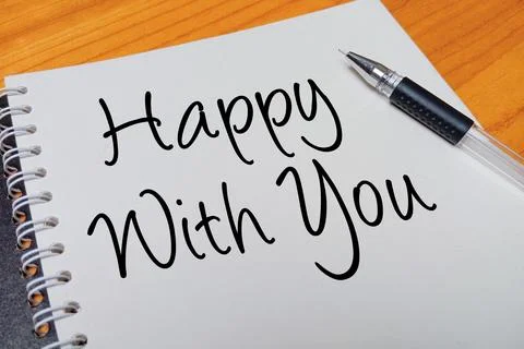Top view of an open spiral notebook with Happy With You handwritten text ov.. Stock Photos