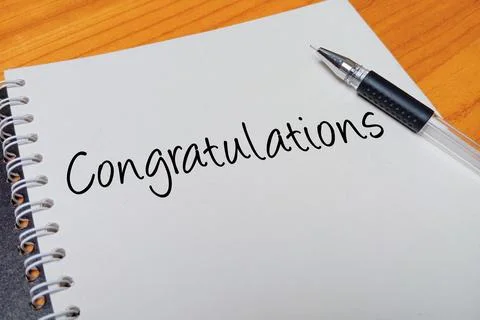 Top view of an open spiral notebook with Congratulations handwritten text o.. Stock Photos