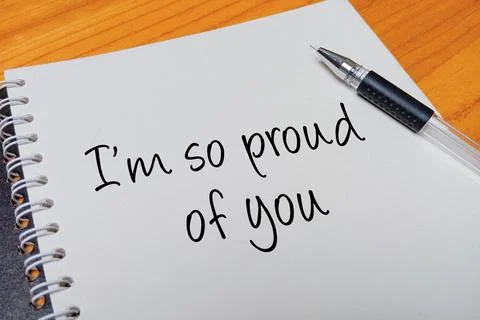 Top view of an open spiral notebook with I'm so proud of you handwritten te.. Stock Photos