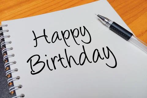 Top view of an open spiral notebook with Happy Birthday handwritten text ov.. Stock Photos