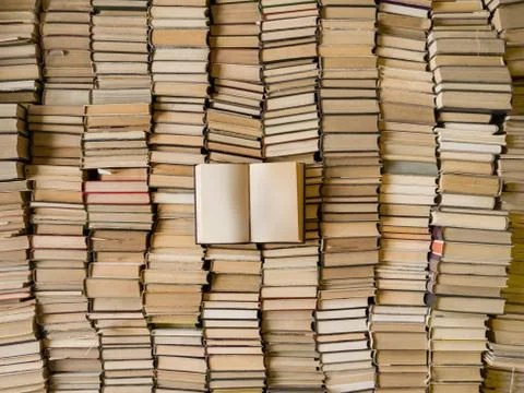 Top view of an opened book over lot of books. Wisdom concept Stock-Fotos