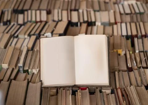 Top view of an opened book over lot of books. Wisdom and knowledge concept. Mock Foto stock