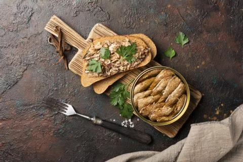 Top view of opened can with fish in oil and sandwich with smoked sprats, pars Stock Photos