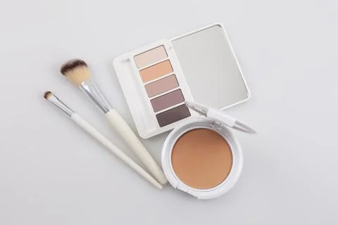 Top view opened compact powder and eyeshadow palette with makeup brushes on.. Foto stock
